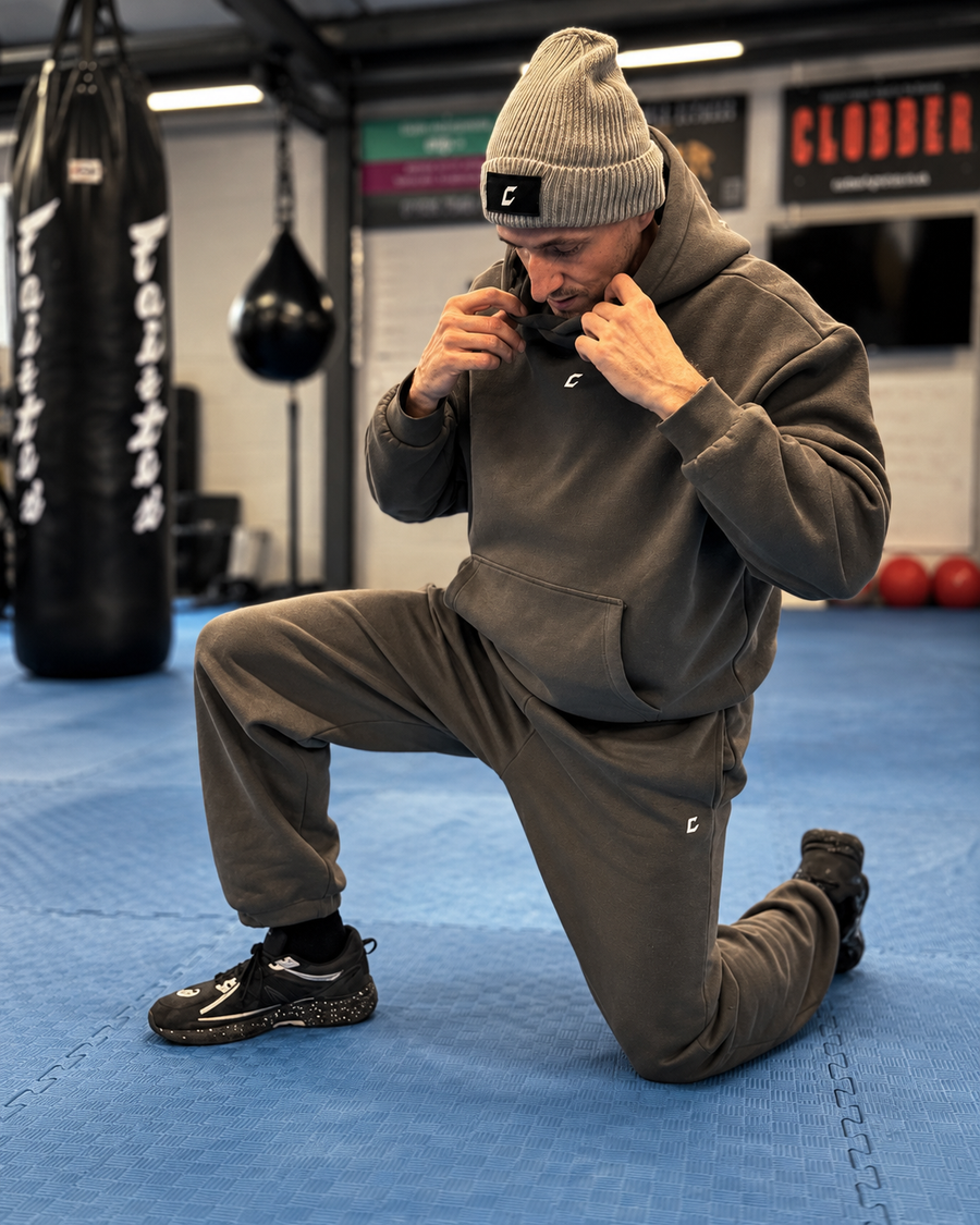 CLOBBER Initial Range grey tracksuit kneeling in the gym